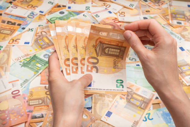 istock Hands counting bills of five, twenty, 50 and 100 euros 1282810063
