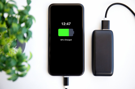 phone with charged battery on the screen connected to powerbank charge
