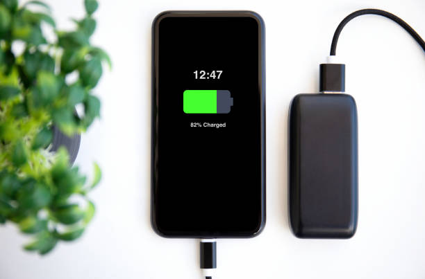 phone with charged battery on the screen connected to powerbank stock photo