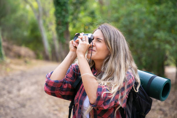 istock Concentrated lady shooting landshate and walking with backpack 1282812392