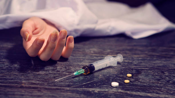 a person dying from excessive alcohol use and syringe, pills, drugs. concept of bad habit with white blanket - narcotic teenager cocaine drug abuse imagens e fotografias de stock