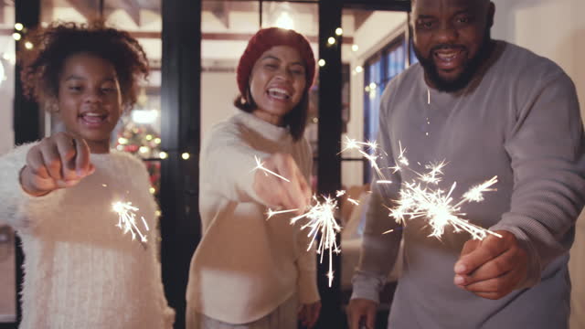 4k resolution Happy family celebrating Christmas and having fun with sparklers