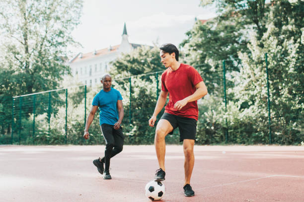 istock two young man playing soccer on hardcourt 1282814937