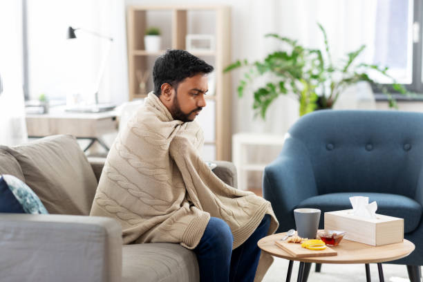 istock sick young man in blanket with hot tea at home 1282815502