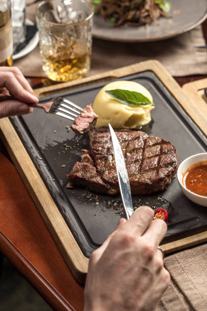 istock man eating steak with mashed potato and tomato sauce at restaurant 1282817569