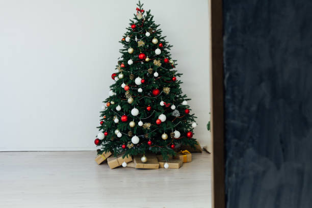 istock Christmas tree pine with gifts interior decor new year 1282820121