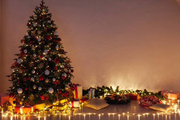 istock Christmas tree pine with gifts light garlands interior decor new year 1282820277
