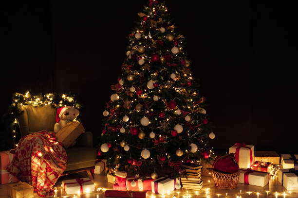 istock Light garlands of Christmas tree decor presents new year night interior 1282821176