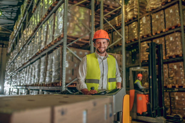 istock Two workers in helmets and vests preparing containers for delivering 1282823537