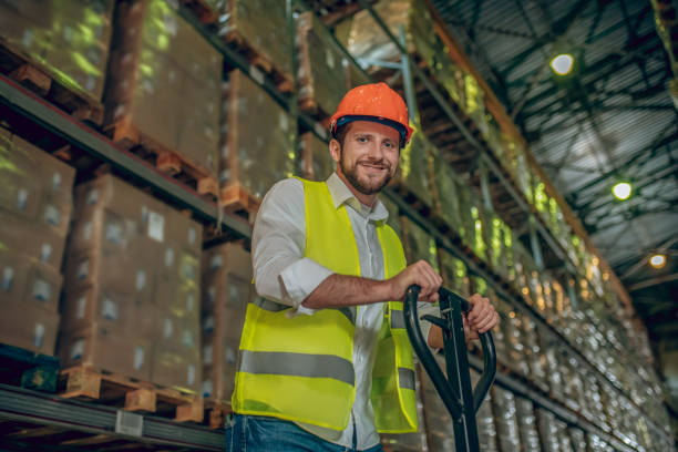 istock Worker in a vest and helmet pushing the loader and looking positive 1282824104
