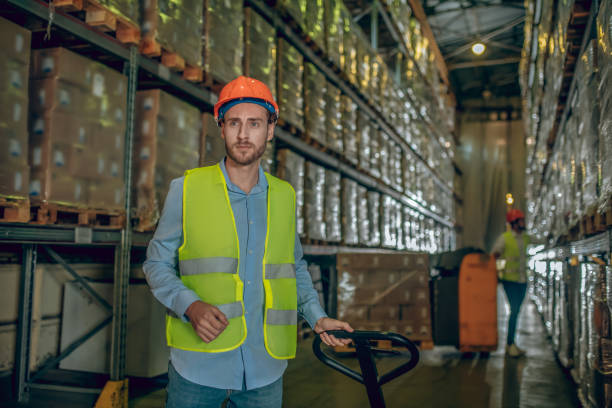 istock Worker in a yellow vest and helmet looking thoughtful 1282824125