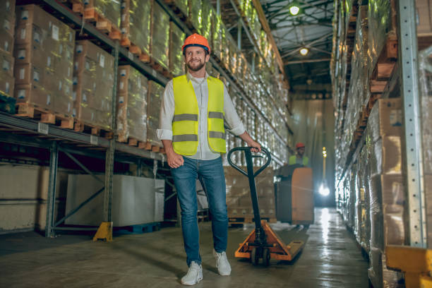 istock Worker in a vest and helmet carrying the loader 1282824130