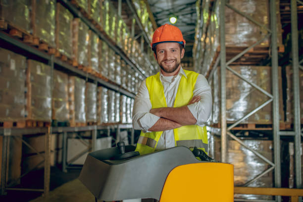 istock Warehouse worker in orange helmet looking contented 1282824174