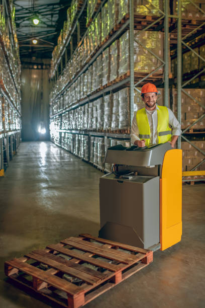 istock Warehouse worker in yellow vest standing in the aisle 1282824221
