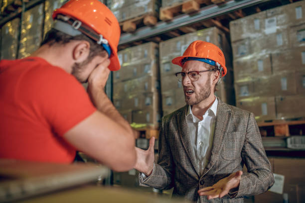 istock Manager having a tough conversation with the warehouse worker and looking angry 1282824383