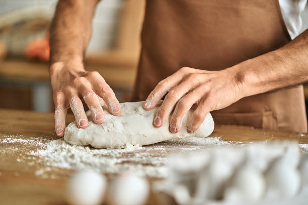 istock Man in a brown apron cooking pastries at home 1282825986