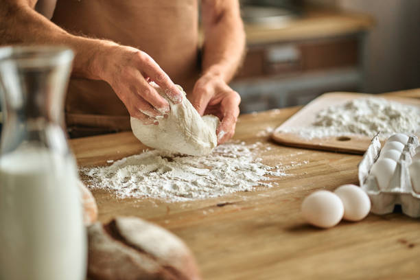 istock Man holding the dough over table where flour is scattered 1282825994