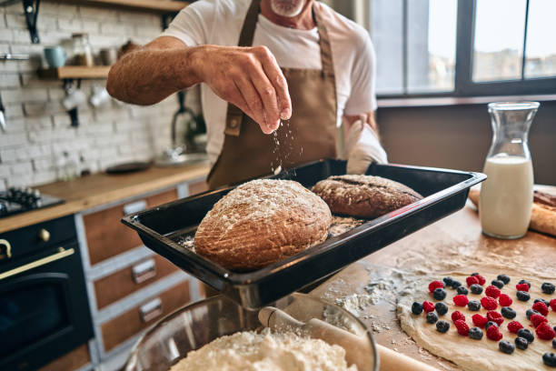istock Mature man in an apron baking homemade bread 1282826177