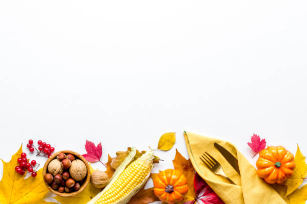 Thanksgiving dinner background with pumpkins leaves and cutlery, top view stock photo