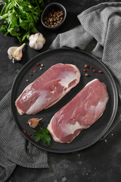 istock Raw duck meat on a black plate. The view from the top 1282826287