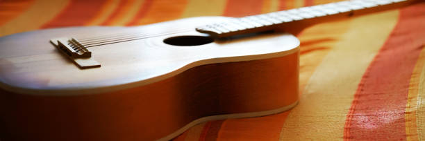 istock wooden guitar lies on striped blanket under bright sunlight 1282827508