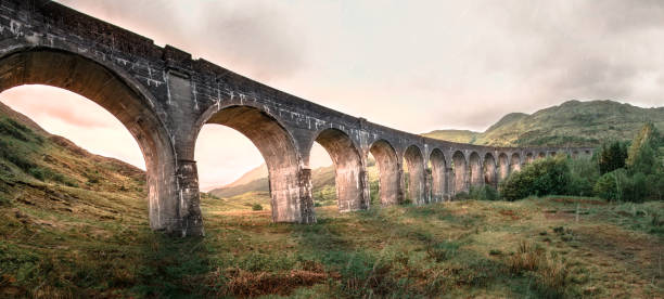 Glenfinnan Railway Viaduct Harry Potter famous Glenfinnan viaduct, Scotland in cloudy weather and sunrise in the background. glenfinnan monument stock pictures, royalty-free photos & images