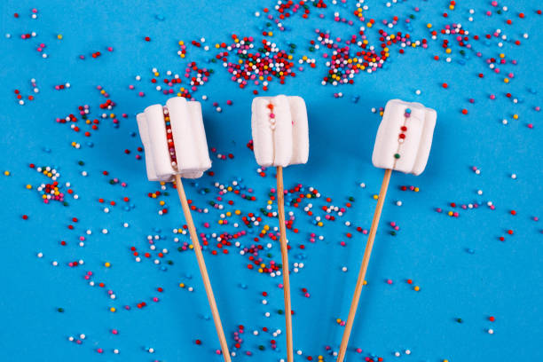 istock marshmallows composition on wooden skewers on blue background. Flat lay, holiday concept. bouquet of sweets 1282827780