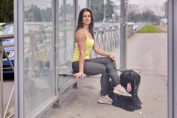 istock Female and black dog wait for bus. 1282828082