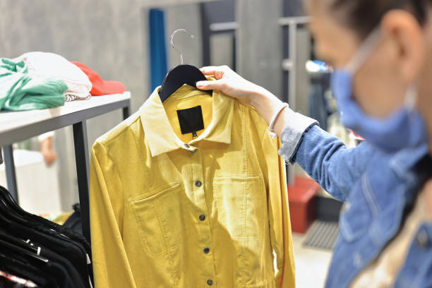 istock Woman in protective mask chooses clothes in store. 1282829437