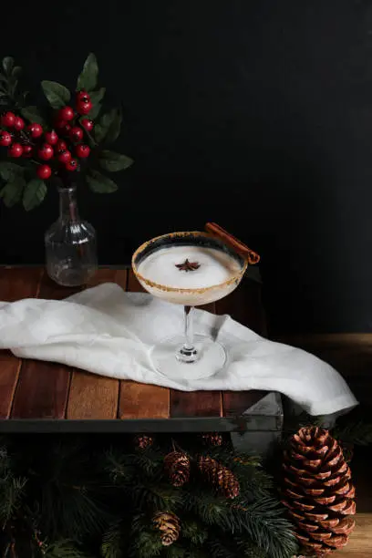 Winter Gingerbread Cocktail with elegant moody look on rustic wood table.