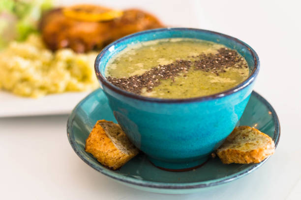 Pureed brocolli soup served with whole grain, chia seed, parmesan cheese