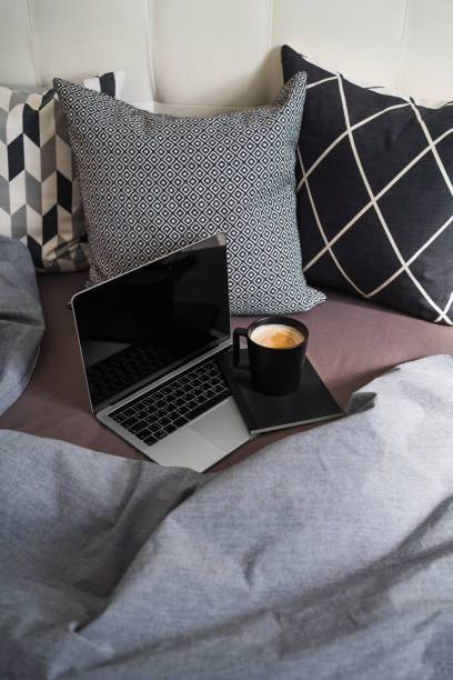 istock Laptop with notebook and a cup of coffee on the bed. Online education. 1282831038