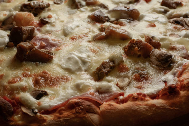 istock Pizza. Capricciosa pizza (Ham, eggplant with garlic, sheep cheese, mushrooms, cheese, mayonnaise, Italian tomato sauce) close-up 1282833325