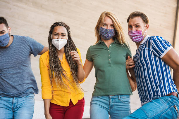 istock Group of friends with protective face masks having fun during coronavirus outbreak - Focus on right blonde girl 1282834810