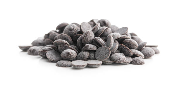 Dark chocolate lentils isolated on white background.