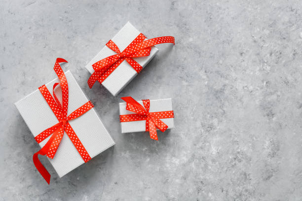 istock Set of gift boxes with red ribbon on gray grunge background. Top view, flat lay, copy space. 1282838420