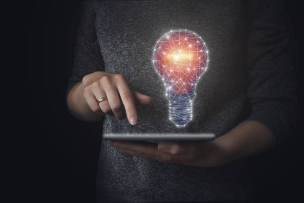 istock Hand holding tablet with drawing light bulb. Close up, idea concept with innovation and inspiration. 1282840977