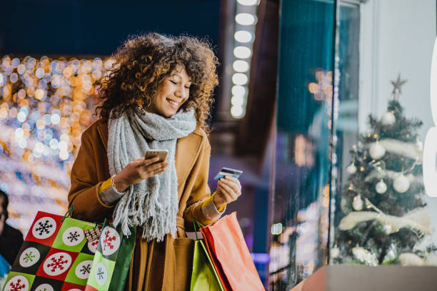 young woman shopping for christmas - christmas shopping imagens e fotografias de stock