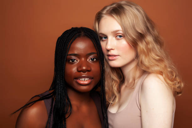 istock two pretty girls african and caucasian blond posing cheerful together on brown background, ethnicity diverse lifestyle people concept 1282852607