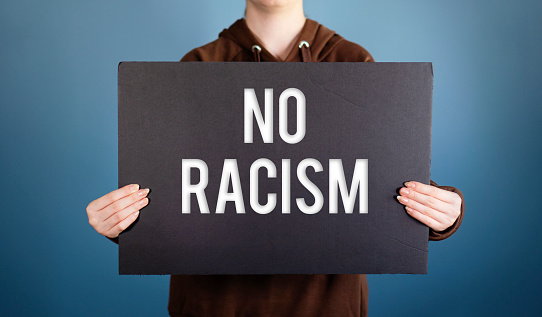 Mixed-race girl holds sign No racism, suffers crowd screaming racial insults, (NO RACISM)