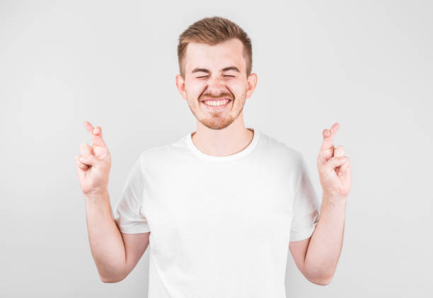 istock Young man making a wish isolated on white background 1282855476