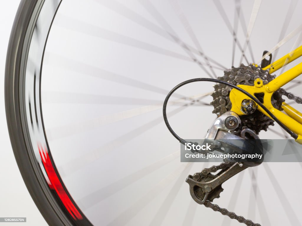 Details of a rear detailleur at the rear wheel of a race bike with spokes in motion blur Bicycle Stock Photo