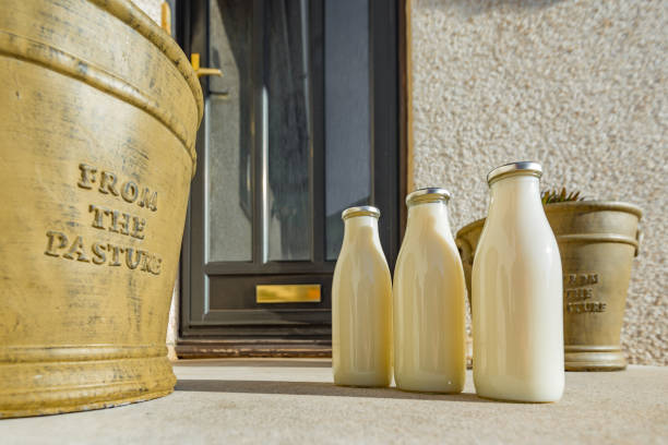 butelki z mlekiem na progu nieruchomości krajowej. - milkman zdjęcia i obrazy z banku zdjęć