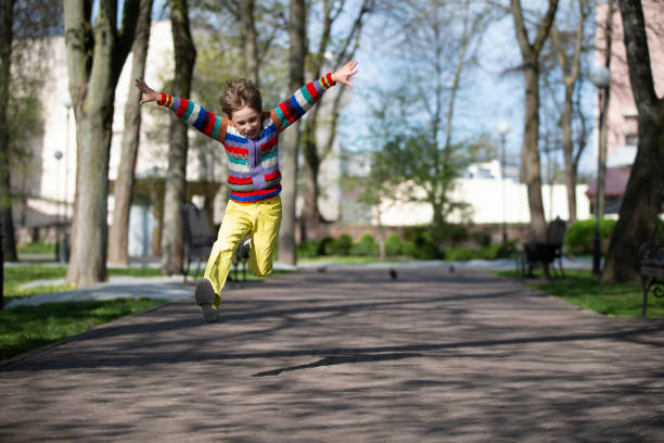 Happy child is jumping up for a walk in the park.