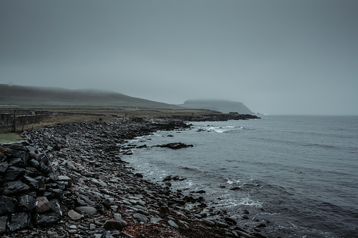 A pebble beach near Sumburgh Head, the southern tip of mainland Shetland, rainy foggy autumn day.