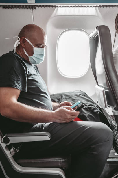 istock Man wearing face mask in an airplane 1282856973