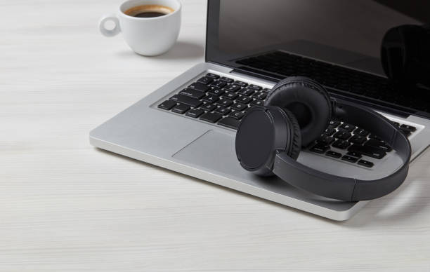 istock Headphones, laptop and coffe cup on desk 1282859323