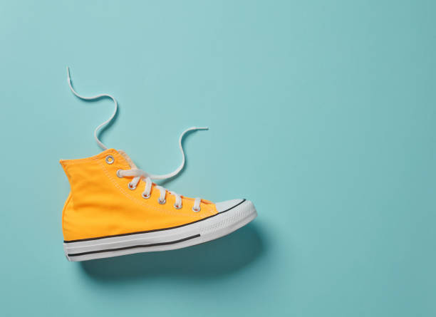 Canvas shoe Yellow canvas shoe on blue background high tops stock pictures, royalty-free photos & images