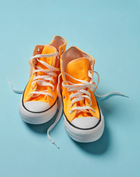 Messy classic shoes Yellow canvas shoes on blue background high tops stock pictures, royalty-free photos & images