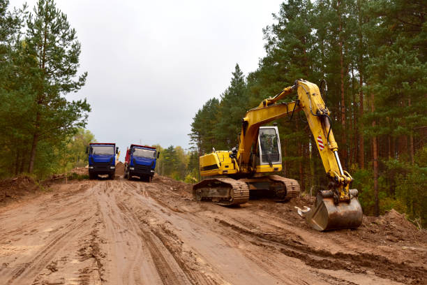 istock Dump trucks and excavator work on road construction in a forest zone 1282860930